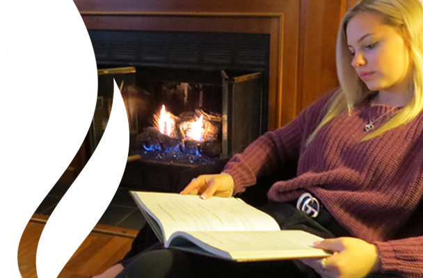 Photo of girl reading by vent free gas fireplace